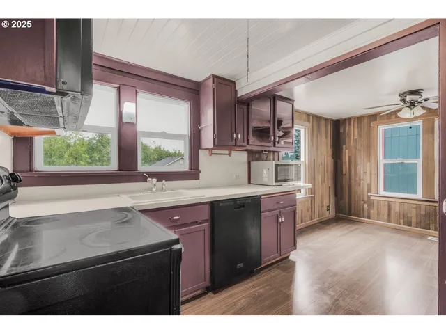 a kitchen with kitchen island granite countertop a sink window and cabinets
