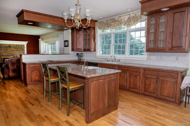 a kitchen with stainless steel appliances granite countertop wooden floors and wooden cabinets