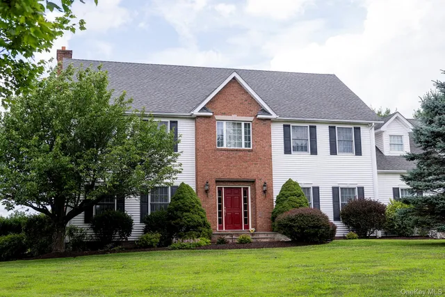 a front view of a house with a yard and trees