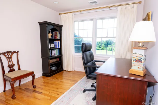 a view of a workspace with furniture and a window