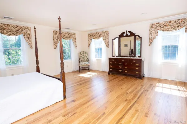 a bedroom with a bed window and a dresser