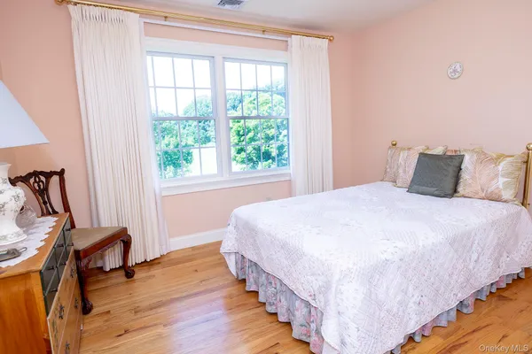 a bedroom with bed and wooden floor