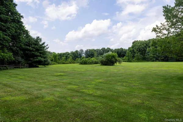 a view of a green field with wooden fence