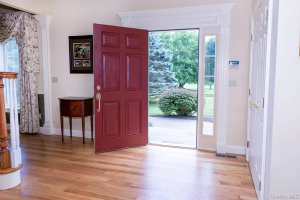a view of hallway with furniture and wooden floor