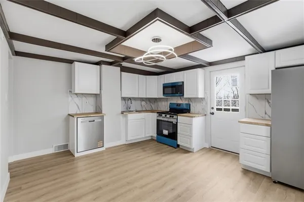 a kitchen with stainless steel appliances granite countertop a refrigerator and a stove