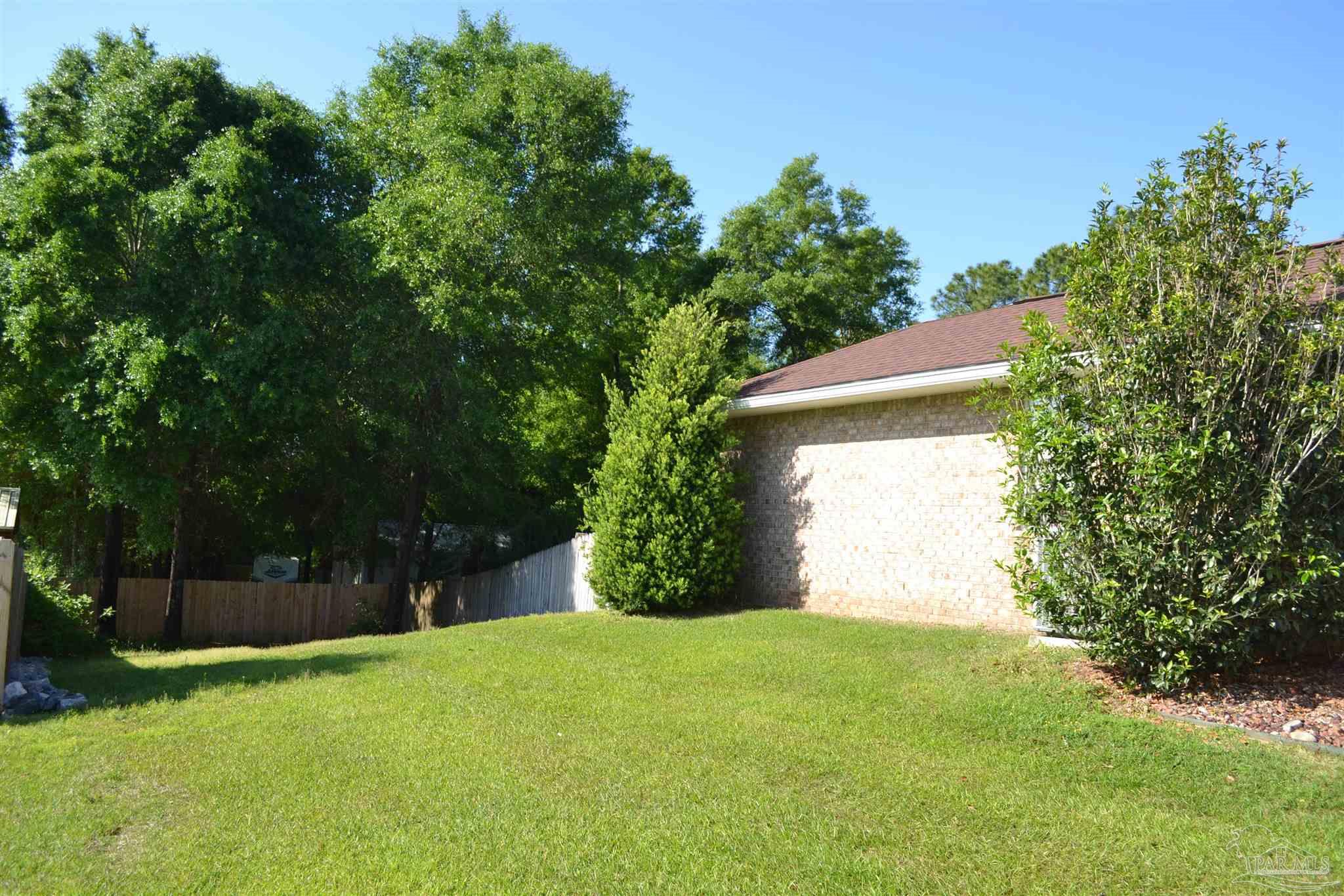 3055 Wallace Lake Road Pace, FL 32571 - Photo 7 of 33 a view of a yard with potted plants and large trees