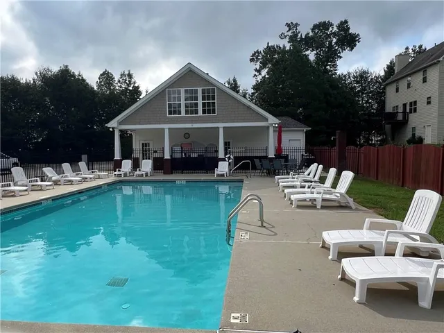 a view of a house with swimming pool and sitting area