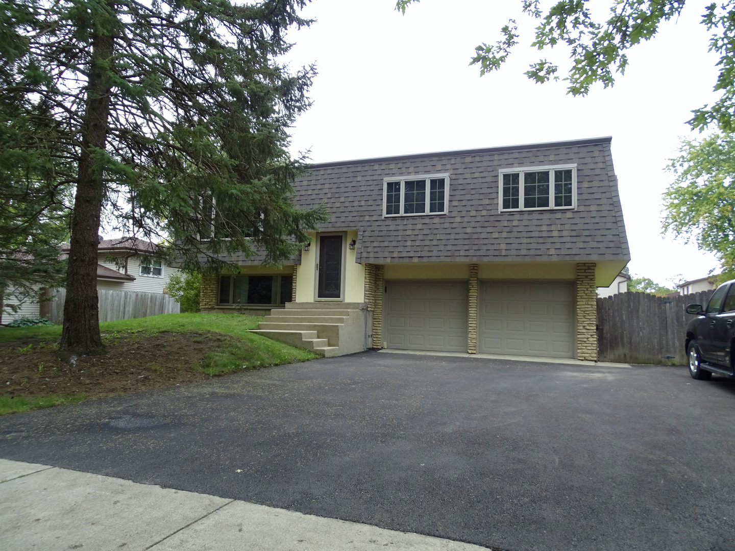 a front view of a house with garage and a yard