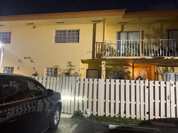 a view of a brick house with a small yard