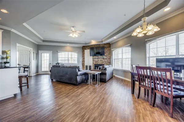 a living room with furniture a chandelier and a wooden floor