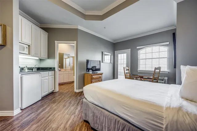 a large bedroom with a bed and wooden floor