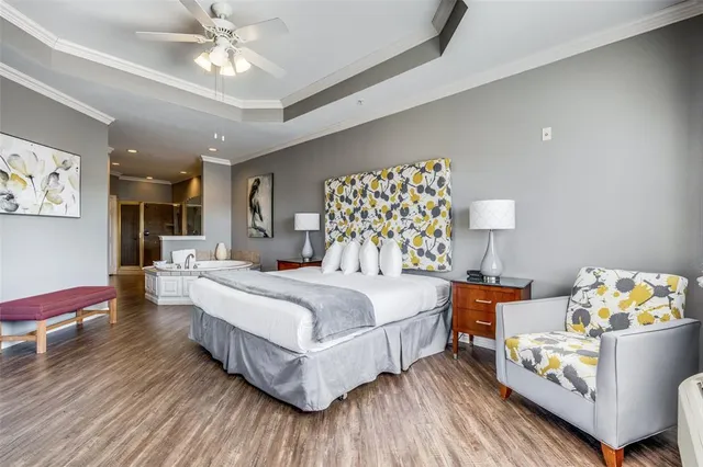 a spacious bedroom with a bed and a chandelier