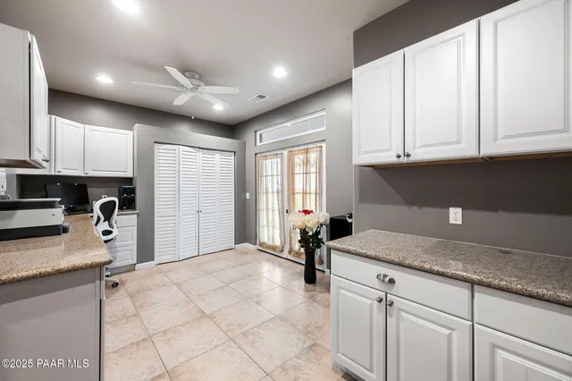 a living room with a dining table and paintings on the wall with wooden floor
