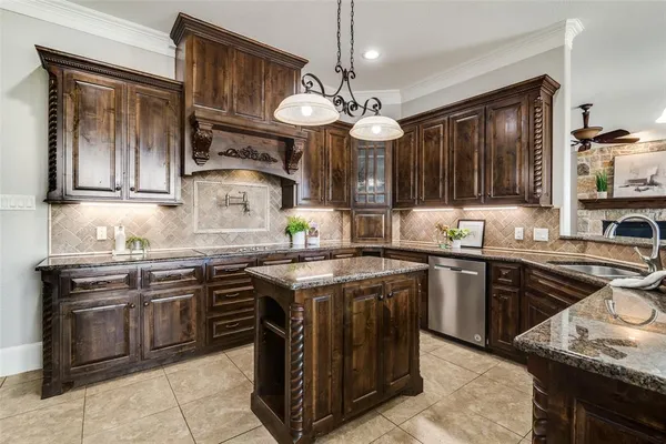 a kitchen with stainless steel appliances granite countertop a stove top oven a sink dishwasher and cabinets with wooden floor