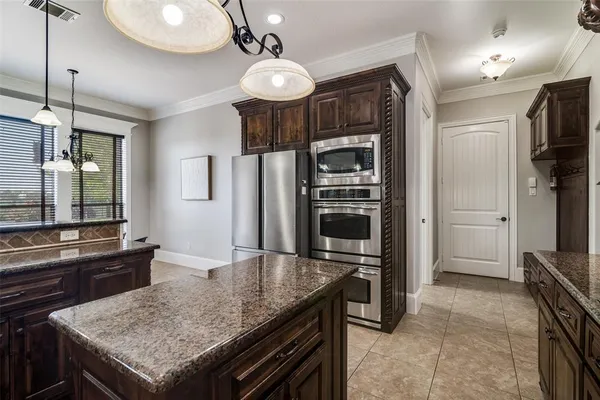 a kitchen with granite countertop a stove refrigerator and microwave