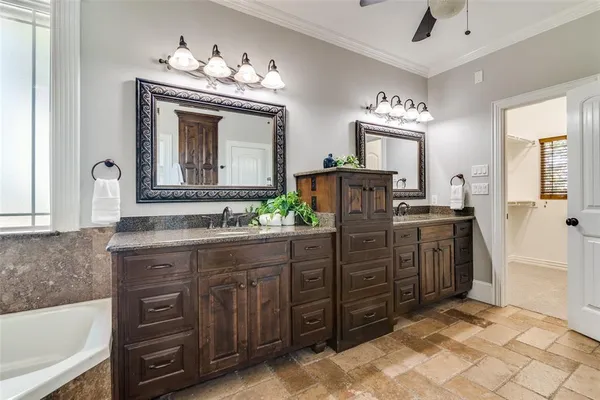 a spacious bathroom with a granite countertop sink a mirror a vanity and bathtub