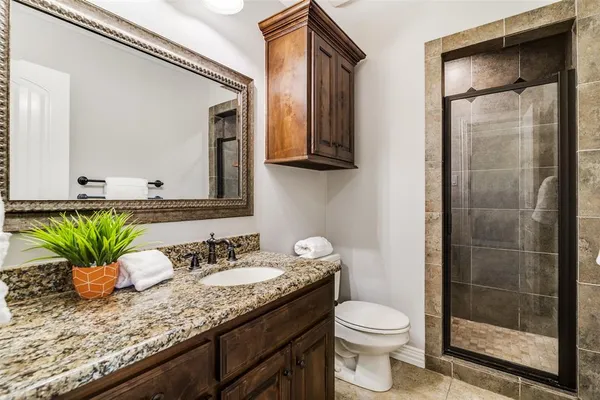 a bathroom with a granite countertop sink a toilet and a mirror