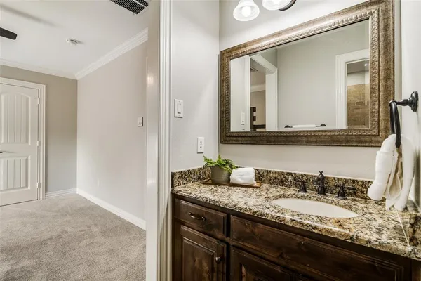 a bathroom with a granite countertop sink and a mirror