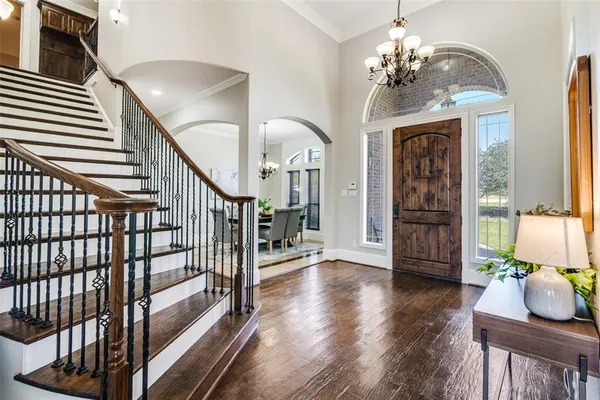 a view of a livingroom with furniture stairs wooden floor and windows