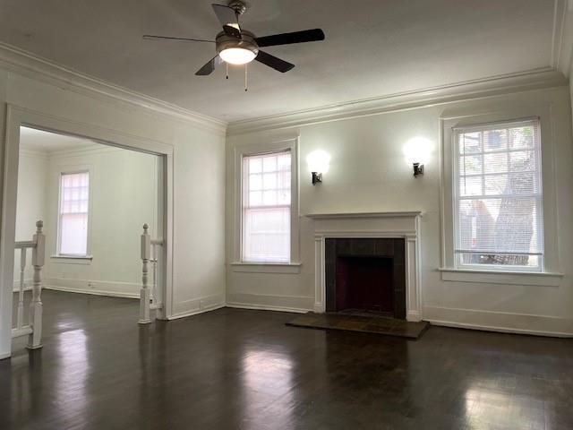 an empty room with wooden floor fireplace and windows