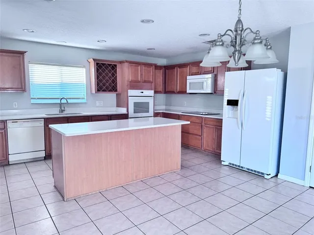 a kitchen with kitchen island granite countertop a sink cabinets and window