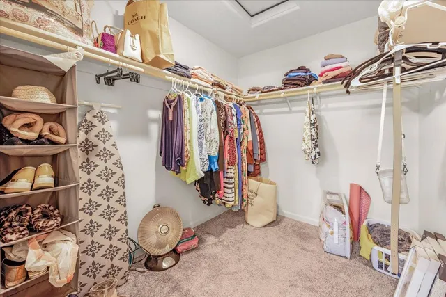 a view of walk in closet with clothes and shoes
