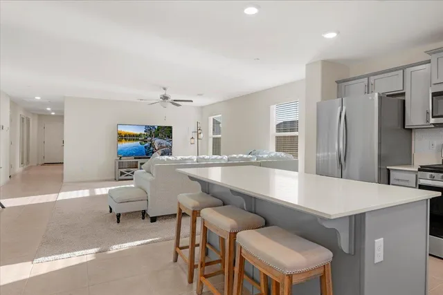 a large kitchen with a table chairs refrigerator and a sink