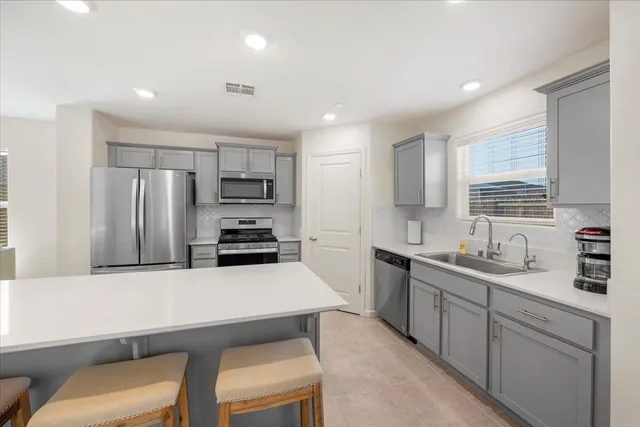 a kitchen with a table chairs refrigerator and microwave