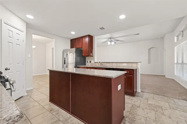 a kitchen with stainless steel appliances granite countertop a sink and a refrigerator