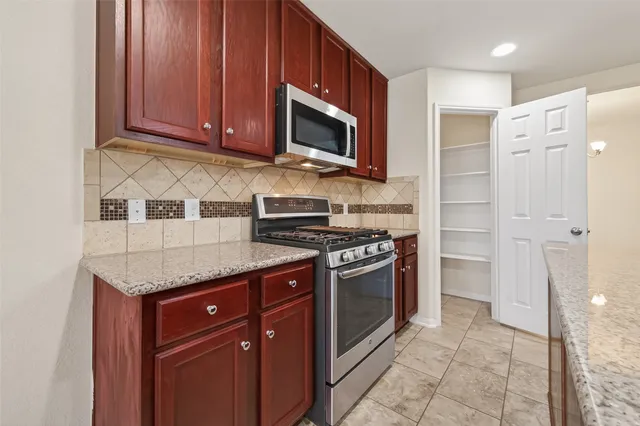 a kitchen with stainless steel appliances granite countertop a stove and a microwave