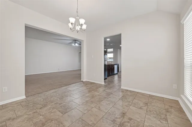 en empty room with kitchen chandelier and glass door