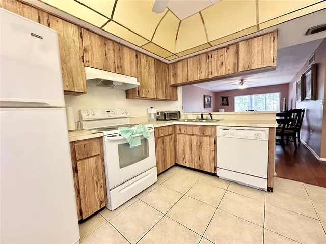a kitchen with stainless steel appliances granite countertop a stove a sink dishwasher and a refrigerator