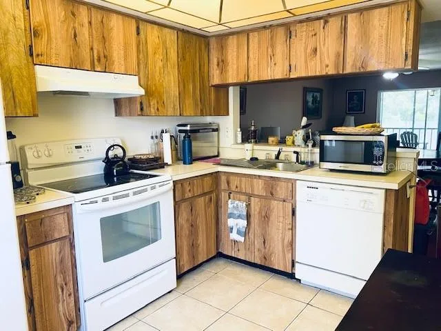 a kitchen with stainless steel appliances a stove microwave and sink