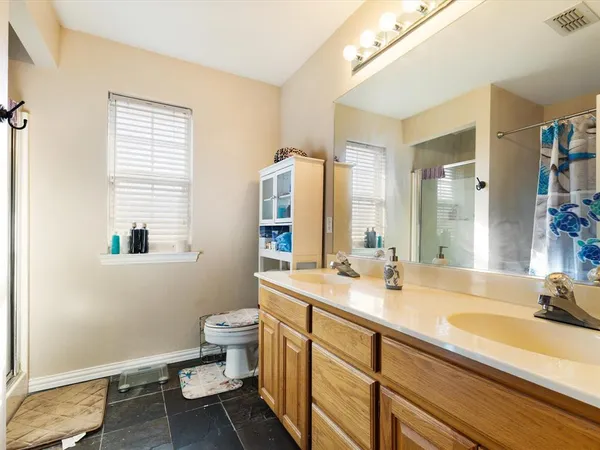 a bathroom with a sink double vanity and a toilet
