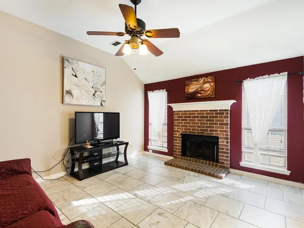 a living room with furniture a fireplace and a flat screen tv