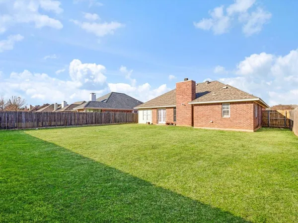 a view of a house with a big yard and a large tree