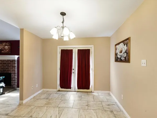 a view of hallway with chandelier and a window