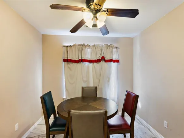 a view of a dining room with furniture and a chandelier fan