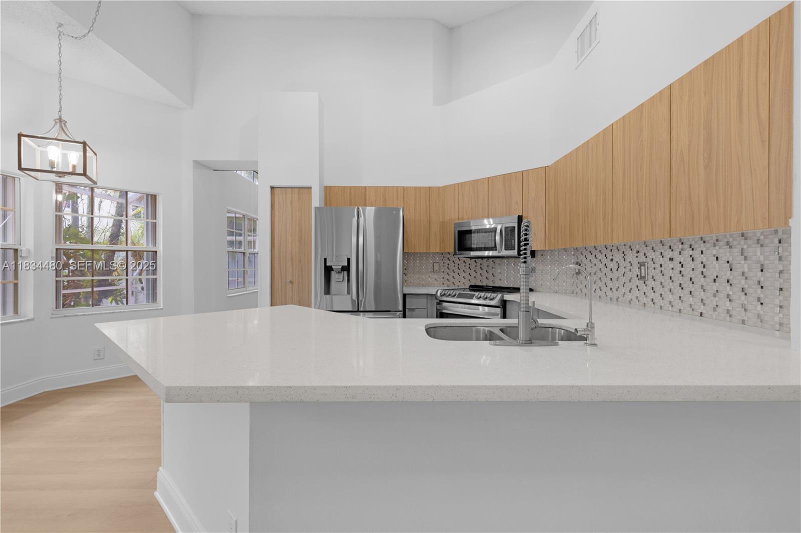 1525 Seabay Road Weston, FL 33326 - Photo 15 of 29 a kitchen with stainless steel appliances a sink a stove cabinets counter top space and a window