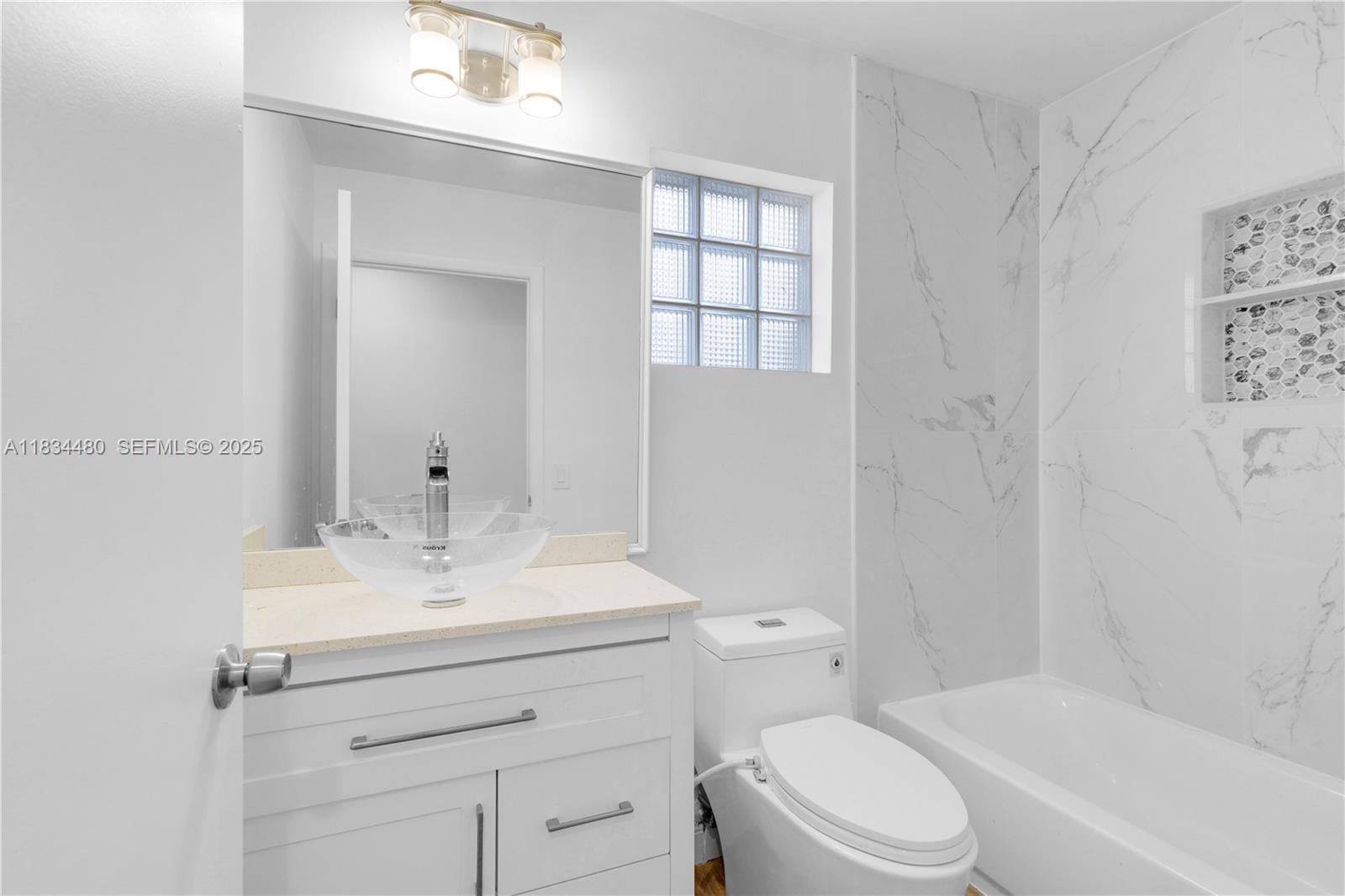 1525 Seabay Road Weston, FL 33326 - Photo 17 of 29 a bathroom with a sink toilet vanity and tub