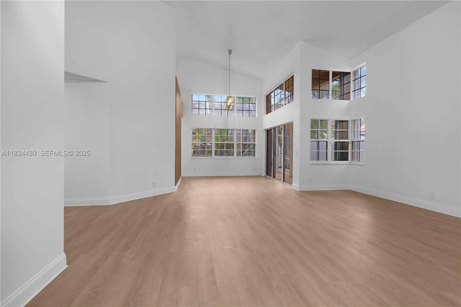 1525 Seabay Road Weston, FL 33326 - Photo 2 of 29 a view of a room with wooden floor and windows