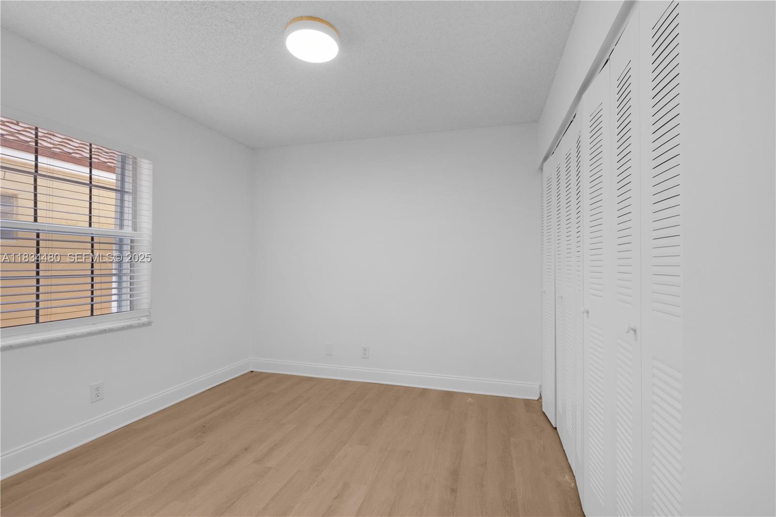 1525 Seabay Road Weston, FL 33326 - Photo 21 of 29 an empty room with wooden floor and windows
