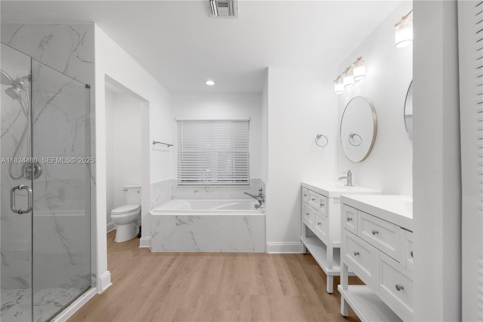 1525 Seabay Road Weston, FL 33326 - Photo 27 of 29 a spacious bathroom with a double vanity sink toilet mirror and bathtub