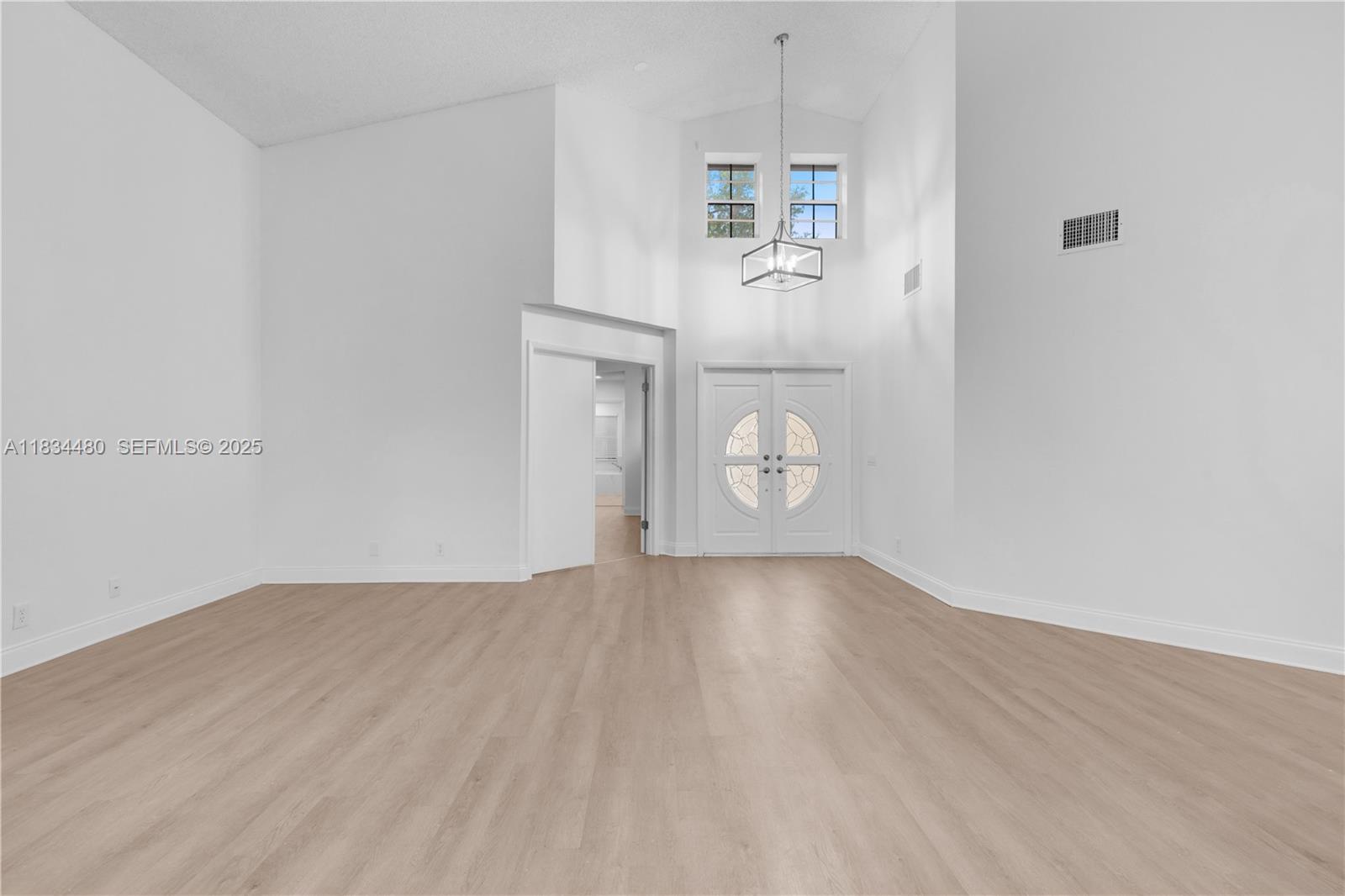 1525 Seabay Road Weston, FL 33326 - Photo 7 of 29 an empty room with wooden floor and cabinet