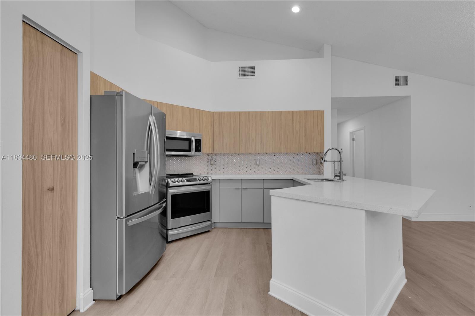 1525 Seabay Road Weston, FL 33326 - Photo 8 of 29 a kitchen with a sink appliances and cabinets