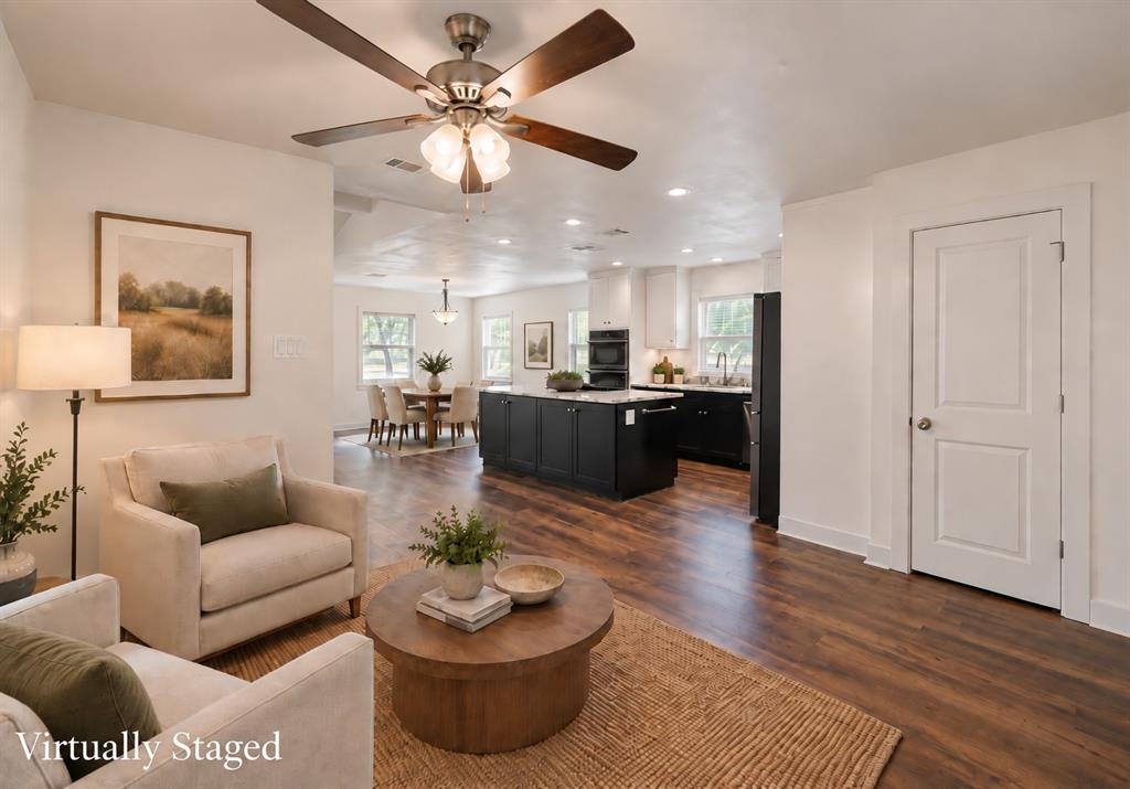 Wood-finish flooring throughout, white walls, ceiling fan with light fixture, recessed lighting, and a solid core interior door