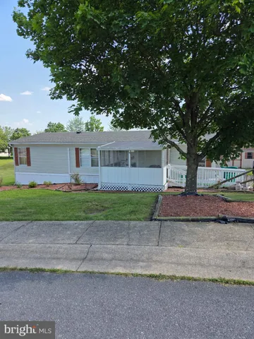 a view of a house with a yard and large tree