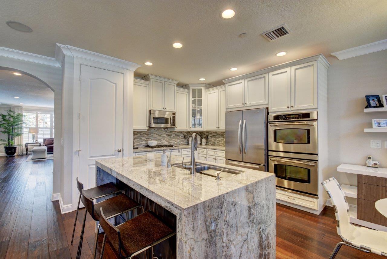 5610 Northeast Trieste Terrace Boca Raton, FL 33487 - Photo 21 of 44 a kitchen with kitchen island granite countertop a stove refrigerator and cabinets