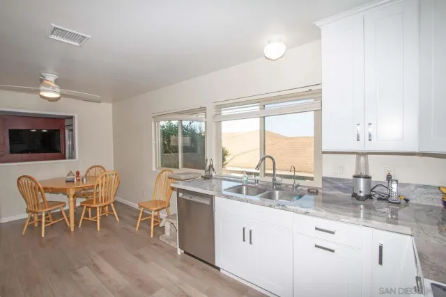 a kitchen with a table chairs sink and cabinets