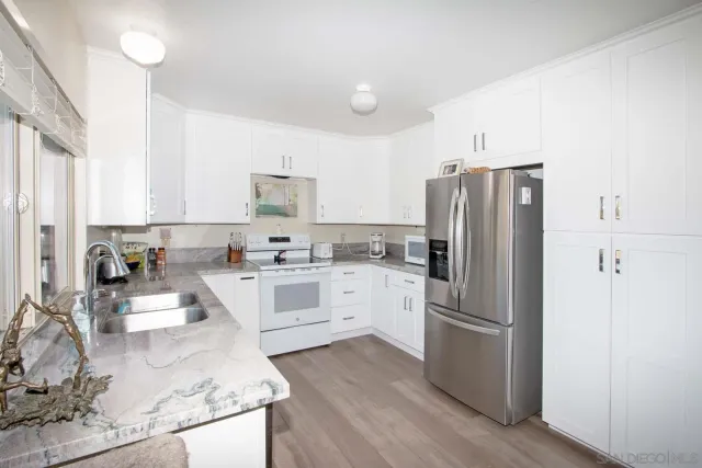 a kitchen with white cabinets and white stainless steel appliances